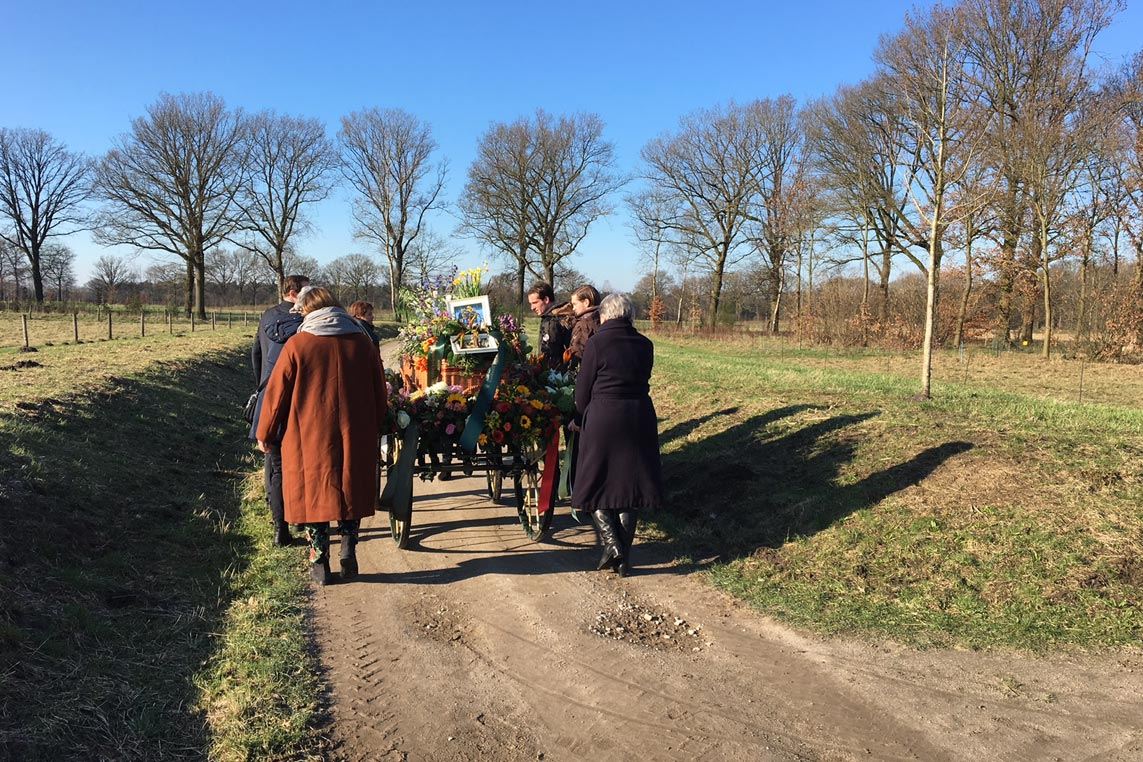 Rouwstoet met paard en koets over een landweg