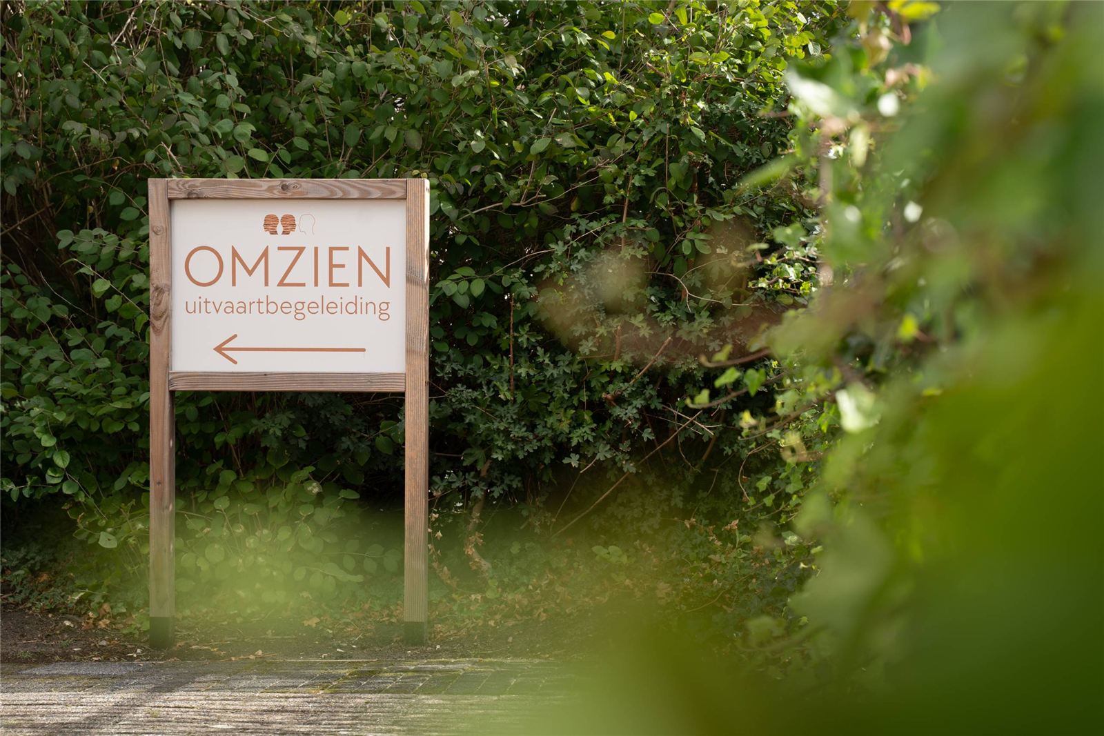 Het bord van Omzien bij de ingang in het groen